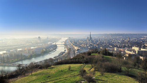 Blick auf die Stadt Rouen mit der Seine, mehreren Brücken und der markanten gotischen Kathedrale bei klarem Himmel