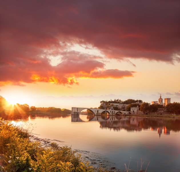 Sonnenuntergang über der historischen Brücke Pont Saint-Bénézet und der Stadt Avignon am Fluss Rhône