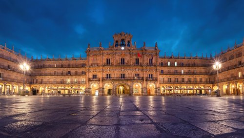Die Plaza Mayor in Salamanca bei Nacht, beleuchtet mit goldenen Lichtern, umgeben von historischen Gebäuden