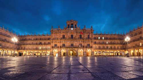Die Plaza Mayor in Salamanca bei Nacht, beleuchtet mit goldenen Lichtern, umgeben von historischen Gebäuden