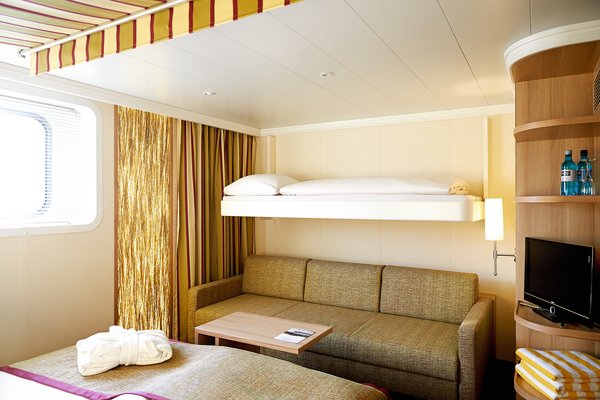 Eine Kabine der Kategorie G der A-ROSA FLORA mit Doppelbett, Schlafsofa und Pullmannbett sowie Fenster und einem Fernseher.