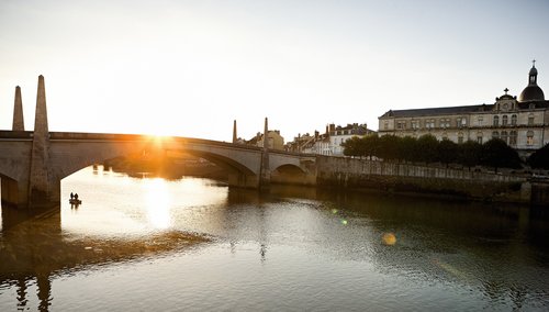 Der Blick n Ufer zum anderen in Chalon-sur-Saône mit historischen Gebäude und einer Brücke bei klarem blauem Himmel. 