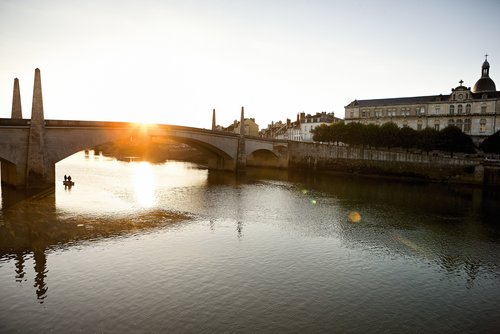 Der Blick n Ufer zum anderen in Chalon-sur-Saône mit historischen Gebäude und einer Brücke bei klarem blauem Himmel. 