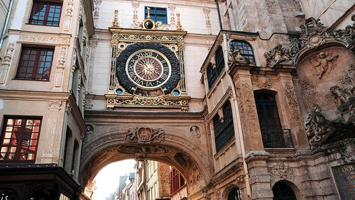 Historische astronomische Uhr mit goldenen Verzierungen an einem Bogen zwischen Gebäuden in Rouen, Frankreich. 
