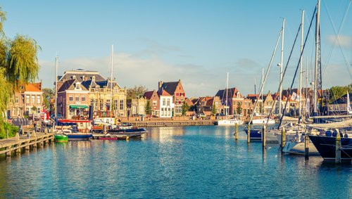 Hafen mit Segelbooten und historischen Gebäuden im sonnigen Enkhuizen, Niederlande
