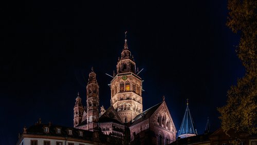 Mainzer Altstadt mit beleuchteten historischen Gebäuden und dem Mainzer Dom im Hintergrund bei Nacht.
