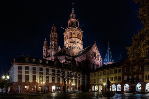 Mainzer Altstadt mit beleuchteten historischen Gebäuden und dem Mainzer Dom im Hintergrund bei Nacht.