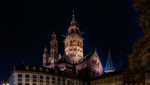 Mainzer Altstadt mit beleuchteten historischen Gebäuden und dem Mainzer Dom im Hintergrund bei Nacht.