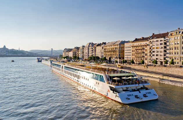 Flusskreuzfahrtschiff am Ufer der Donau in Budapest mit historischen Gebäuden und der Kettenbrücke im Hintergrund
