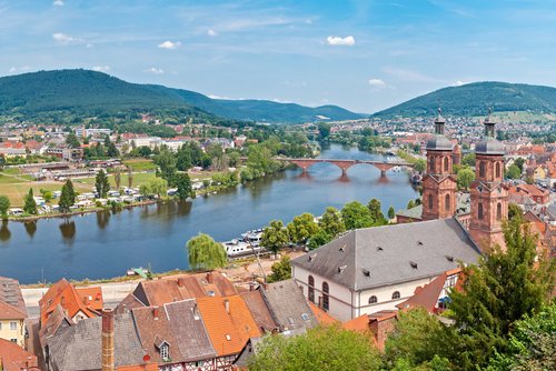 Panorama der Stadt Miltenberg mit historischen Fachwerkhäusern und Fluss im Vordergrund und dem Stadtzentrum im Hintergrund am anderen Flussufer