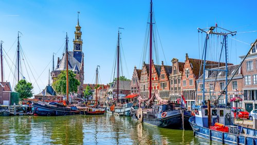 Historischer Hafen von Hoorn mit Segelschiffen und Giebelhäusern unter blauem Himmel