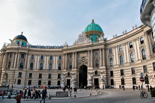 Die Hofburg in Wien mit ihrer markanten Kuppel und vielen Menschen auf dem Platz davor.