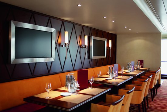 Stilvoll eingedeckter Restaurantbereich der A-ROSA AQUA und BRAVA mit gemütlicher Beleuchtung und bodentiefen Fenstern.