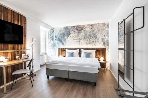 Doppelzimmer im Hotel Blauer Bock Passau mit Doppelbett, Wandkunst, Schreibtisch, Fernseher und Spiegel